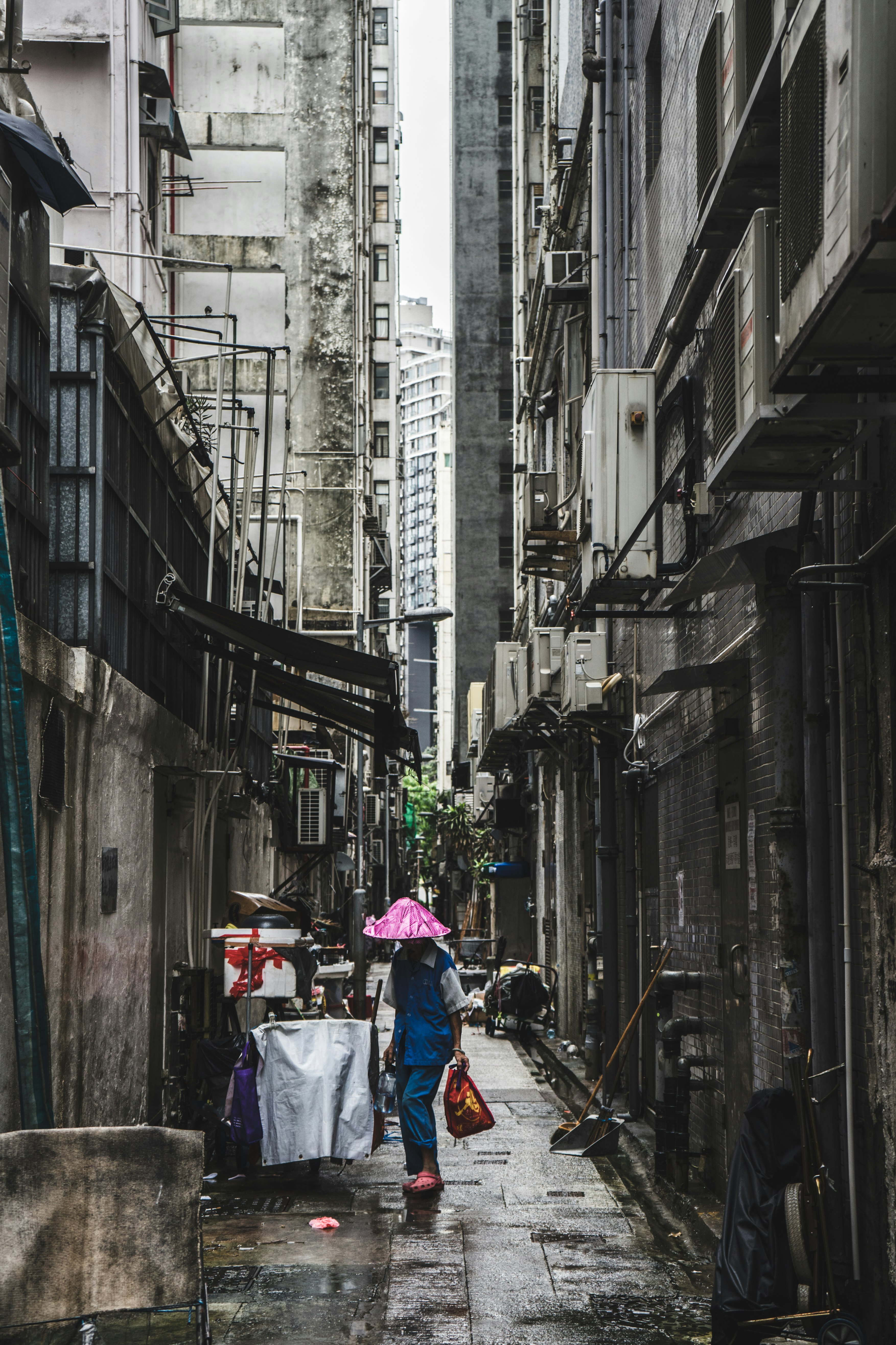 person carrying red bag in alley